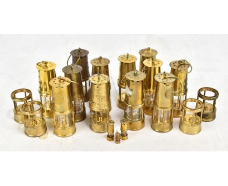 A group of miniature Protector Lamp &amp; Lighting Co Ltd Eccles miners' safety lamps and four spare lower sections.