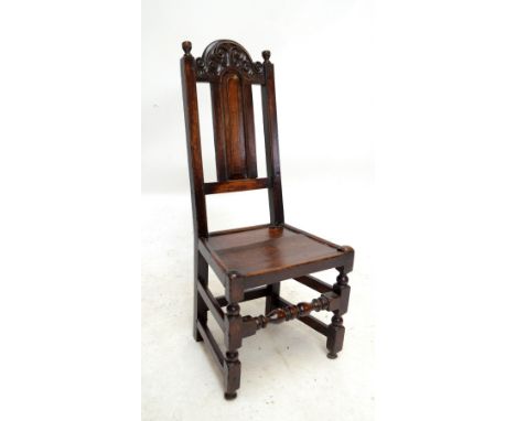 A late 17th century Yorkshire oak back stool with carved arched top rail, dished plank seat and baluster ring turned and bloc