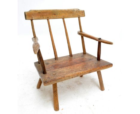 A late 18th century rustic pine stick-back low elbow chair.