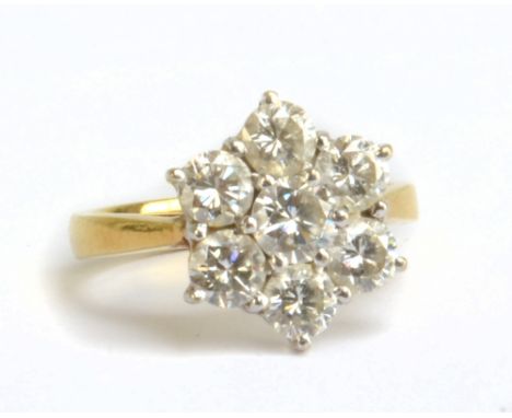 An 18ct yellow gold diamond set floral ring, the central stone weighing approx 0.25ct within a border of six stones, each wei