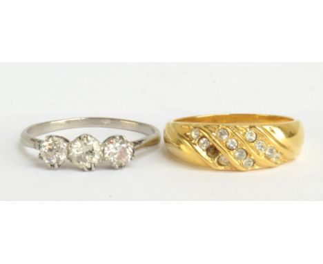 An unmarked white metal three stone diamond ring, size O1/2 and a yellow metal ring, size N1/2, combined approx 5.3g (2).