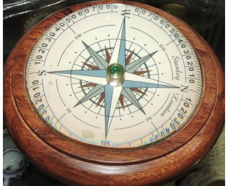 A wooden paperweight with a large compass