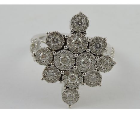 A diamond cluster ring of snowflake design, with an arrangement of twelve stones, approx. 1.3ct, on a white metal band with d