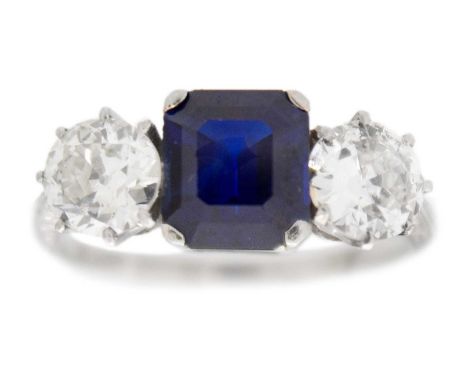 A superb natural sapphire, possibly Burmese, diamond three-stone ring The violet-blue emerald-cut sapphire is 2.5ct approx. w