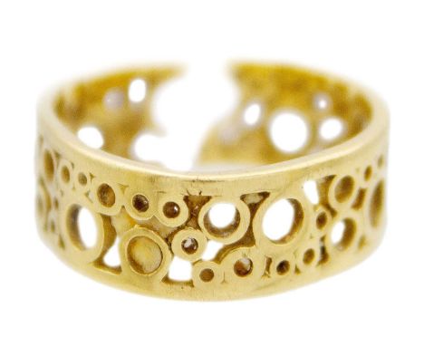 An 18k openwork band ring by Tiffany & Co. The band formed with various sized open circles, hallmarked London 1971, stamped T