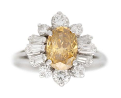A champagne diamond cluster ballerina white gold ring. The oval brilliant-cut central diamond is 7mm x 5mm, surrounded by six
