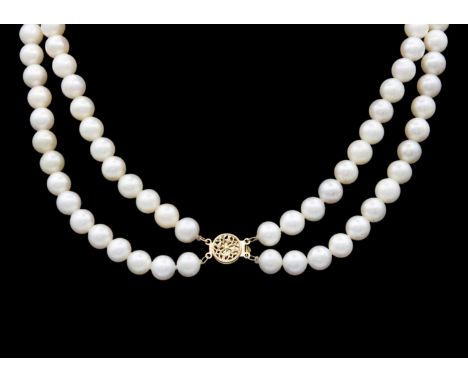 A cultured white pearl double-strand necklace with a 14k clasp. The uniform pearls of 7.5-8mm, the pierced disc clasp stamped