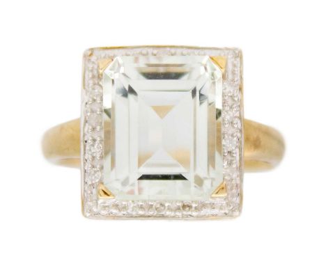 A rock crystal quartz and diamond ring in 9k yellow gold. A rectangular shape, emerald-cut quartz, 11mm x 9mm, surrounded by 