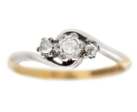 An early 20th century 9k gold and platinum three-stone diamond crossover ring. The principal stone is 0.10ct approx. (2.5mm),