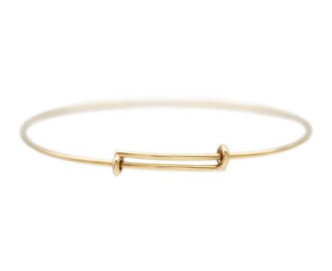 A Tiffany & Co 9k gold adjustable wire bangle. Diameter 7cm approx., stamped T&amp;Co, London hallmarked, weight 5.29g.