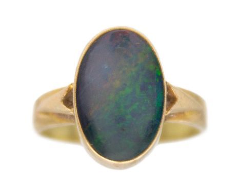 An opal triplet solitaire ring in 9k yellow gold. The oval cabochon triplet opal is 14mm x 9mm, bezel set, size O1/2, 3.9g, t
