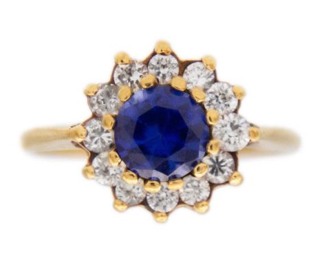 A 9k gold synthetic sapphire and CZ halo ring. The round mixed-cut sapphire diameter is 6mm approx., surrounded by twelve CZ,