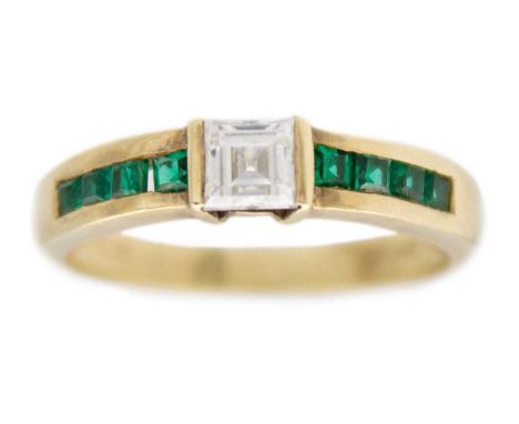 A 9k yellow gold CZ ring. The central square step-cut white CZ is 4mm, channel set with four green square-shaped CZ on each s