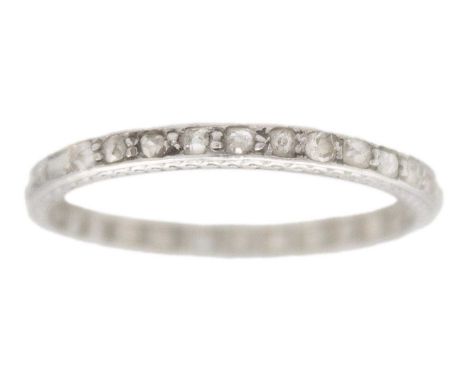 An early 20th century platinum diamond set full eternity ring. Set with small, mixed-cut diamonds, the band sides with engrav