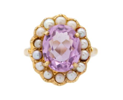 An amethyst and split seed pearl 9k gold dress ring. The oval-shaped mixed-cut amethyst is 11mm x 9mm, surrounded by fourteen