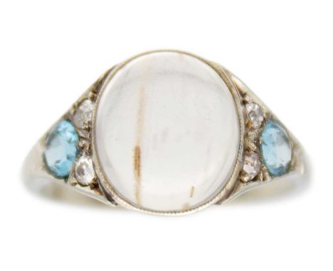 A moonstone, topaz, and diamond 18k white gold art-deco ring. The oval cabochon moonstone is 10mm x 9mm, a millegrain bezel s