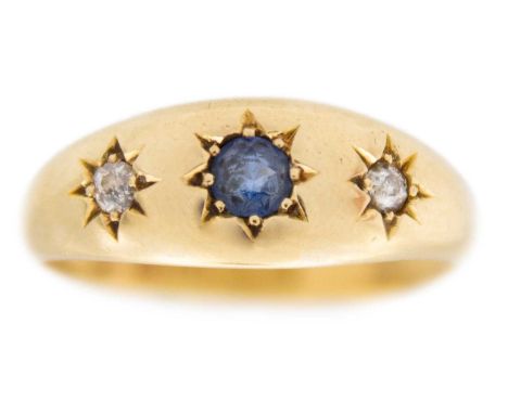 An 18k gold three-stone sapphire and diamonds gypsy-style band ring. Blue sapphire, 3mm,  with two small white diamonds, Birm