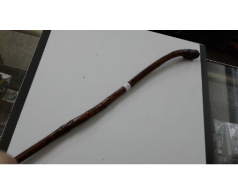 A carved wooden walking stick, possibly P.O.W.