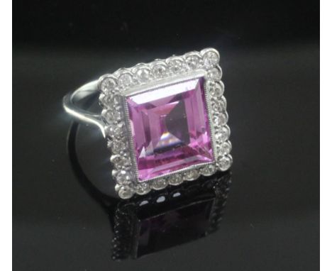 A mid 20th century 18ct white gold, pink sapphire and diamond cluster dress ring, the rectangular cut sapphire with the dimen