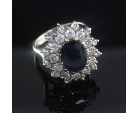 An 18ct white gold, sapphire and diamond oval cluster ring, size K.