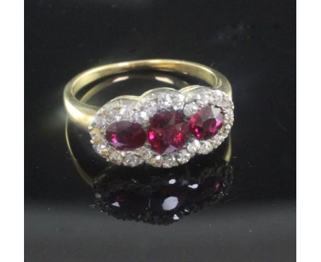 A gold, ruby and diamond triple cluster ring, size K.