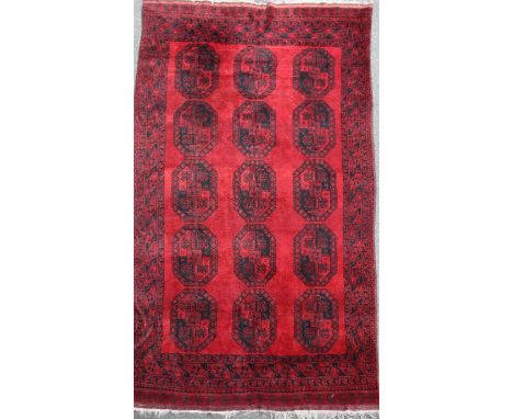A North West Persian red ground carpet, with field of fifteen octagons, 12ft 3in by 7ft 9in.
