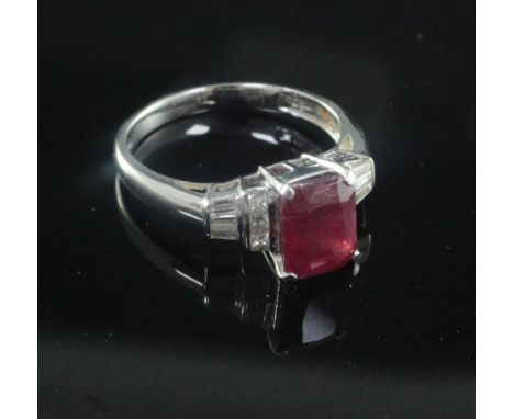 A modern 18ct white gold, ruby and diamond ring, with central emerald cut ruby, flanked by princess and baguette cut diamonds