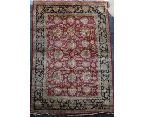 A large Agra red ground carpet, with gold floral decoration and three row floral borders and guards, 12ft 2in by 9ft 2in.