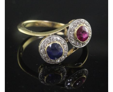 A mid 20th century 18ct gold, ruby, sapphire and diamond double cluster crossover ring, size P.