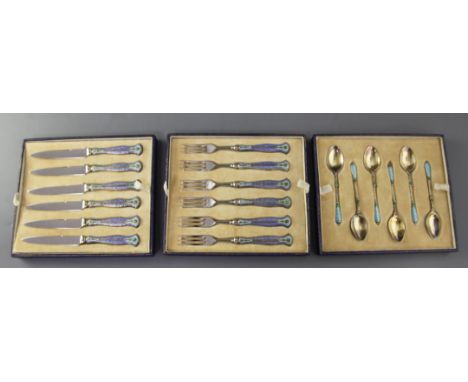 A cased set of six pairs of 1930's silver gilt and polychrome enamel handled stainless steel fruit eaters, together with six 
