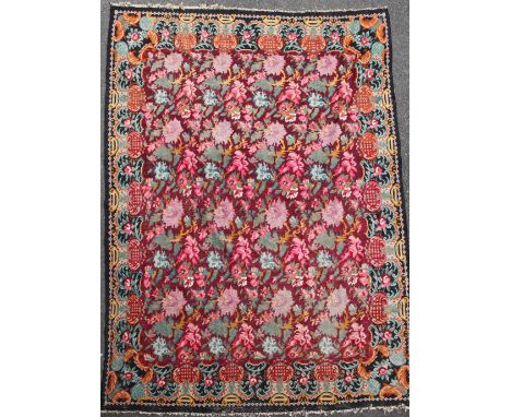 A large Kelim carpet, with polychrome floral field on a puce ground, 11ft 2in by 8ft 1in.