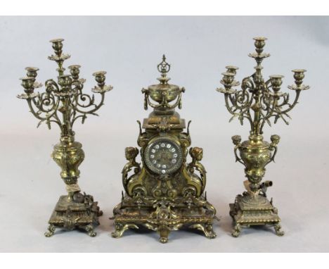 An early 20th century French bronze three piece clock garniture, with urn surmounted mantel clock, 23in., and a pair of six l