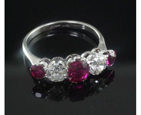 A 1940's platinum and graduated five stone ruby and diamond half hoop ring, size Q.