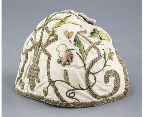 An early 18th century embroidered silk and metal thread cap, woven with flowers and scrolling foliage on ivory satin ground