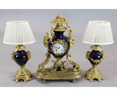 A French ormolu and bleu du rois porcelain clock garniture, with central urn shaped clock, 22in., and a pair of side ornament