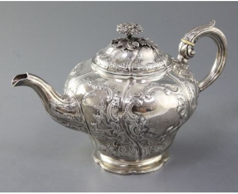 A Victorian silver teapot, of inverted pear shape and embossed with figures and dogs in hunting scene amid a scrolling border