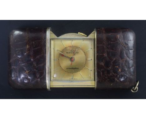 A gilt and leather outer cased Movado Ermetophon travelling watch, with baton numerals.