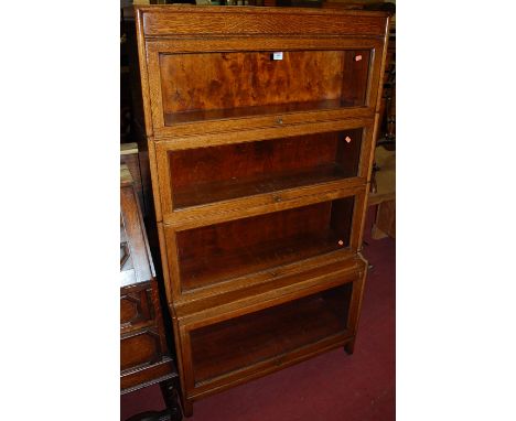 A 1930s Globe Wernicke style four tier stacking bookcase, having typical hinged glazed doors and protruding lower compartment