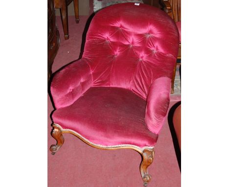 A mid Victorian walnut framed and button back upholstered tub armchair