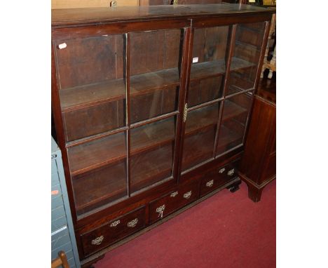 An antique mahogany double door glazed bookcase, having three short lower drawers on ogee bracket supports, width 126.5cm   C