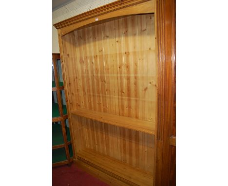 A large modern pine round cornered freestanding open bookshelf, having one central fixed shelf, and further adjustable shelvi