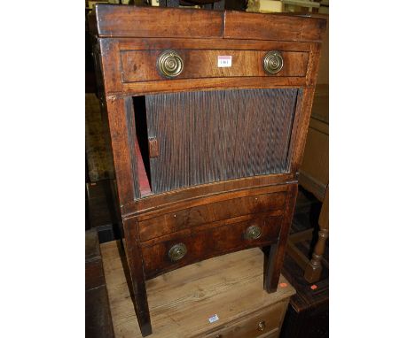 An early 19th century mahogany bedside commode having twin hinged top over tambour front door to further pull-out lower compa