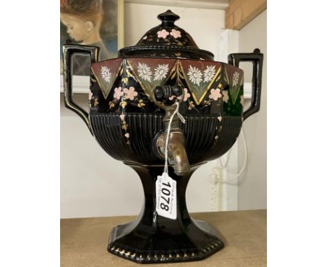 A 19th century hand painted black ceramic urn with brass tap.
