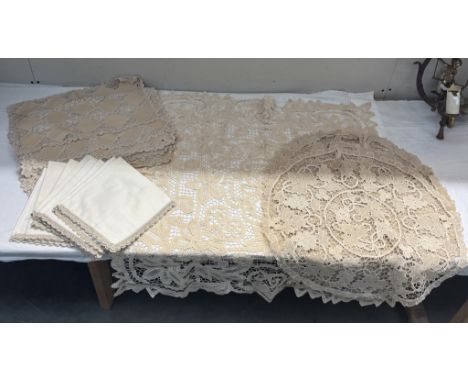 A lace tablecloth, 3 round lace tablecloths, 8 placemats, 8 matching serviettes