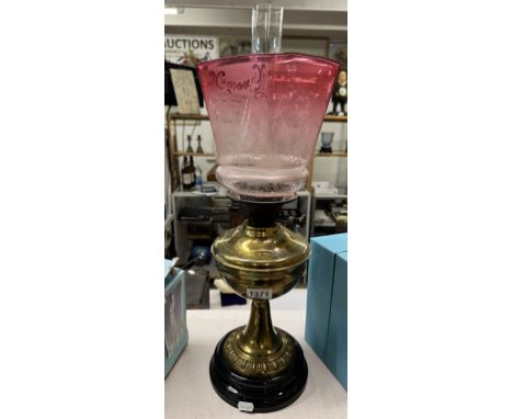 A Victorian oil lamp with acid etched cranberry glass shade No damage to shade or chimney , brass patinated 
