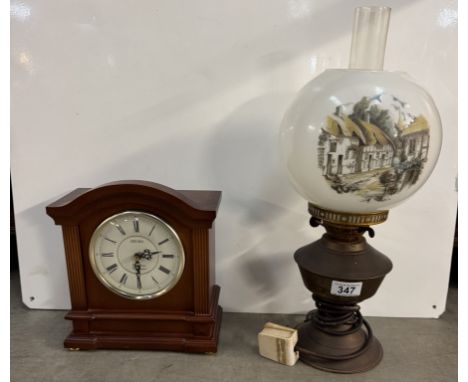 An electric brass oil lamp with thatched cottage shade &amp; a Seiko Westminster/Whittington chime quartz clock