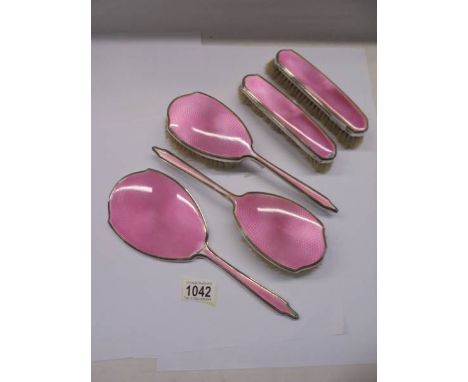 A Mappin &amp; Webb five piece silver and pink enamel dressing table set (some minor enamel loss).