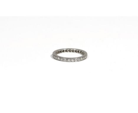 A diamond-set eternity ring, claw-set with circular-cut diamonds, to a white precious metal mount, ring size K, 2.6g gross.