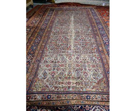 A Fereghan kelleh carpet, Persian, the sage field with an allover hearate design; an indigo palmette border, 377cm x 194cm.