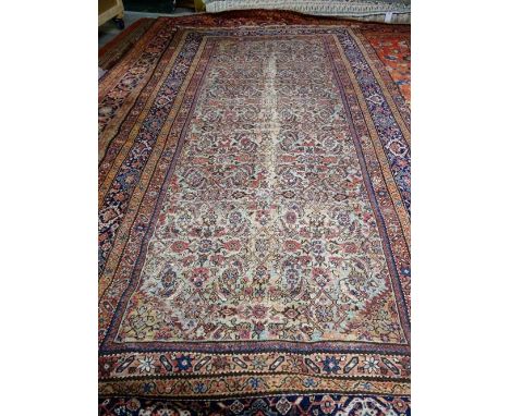 A Fereghan kelleh carpet, Persian, the sage field with an allover hearate design; an indigo palmette border, 377cm x 194cm.